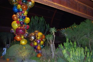 The "Polyvitro Chandelier and Tower' hangs from the metal beams of the Succulent Gallery.